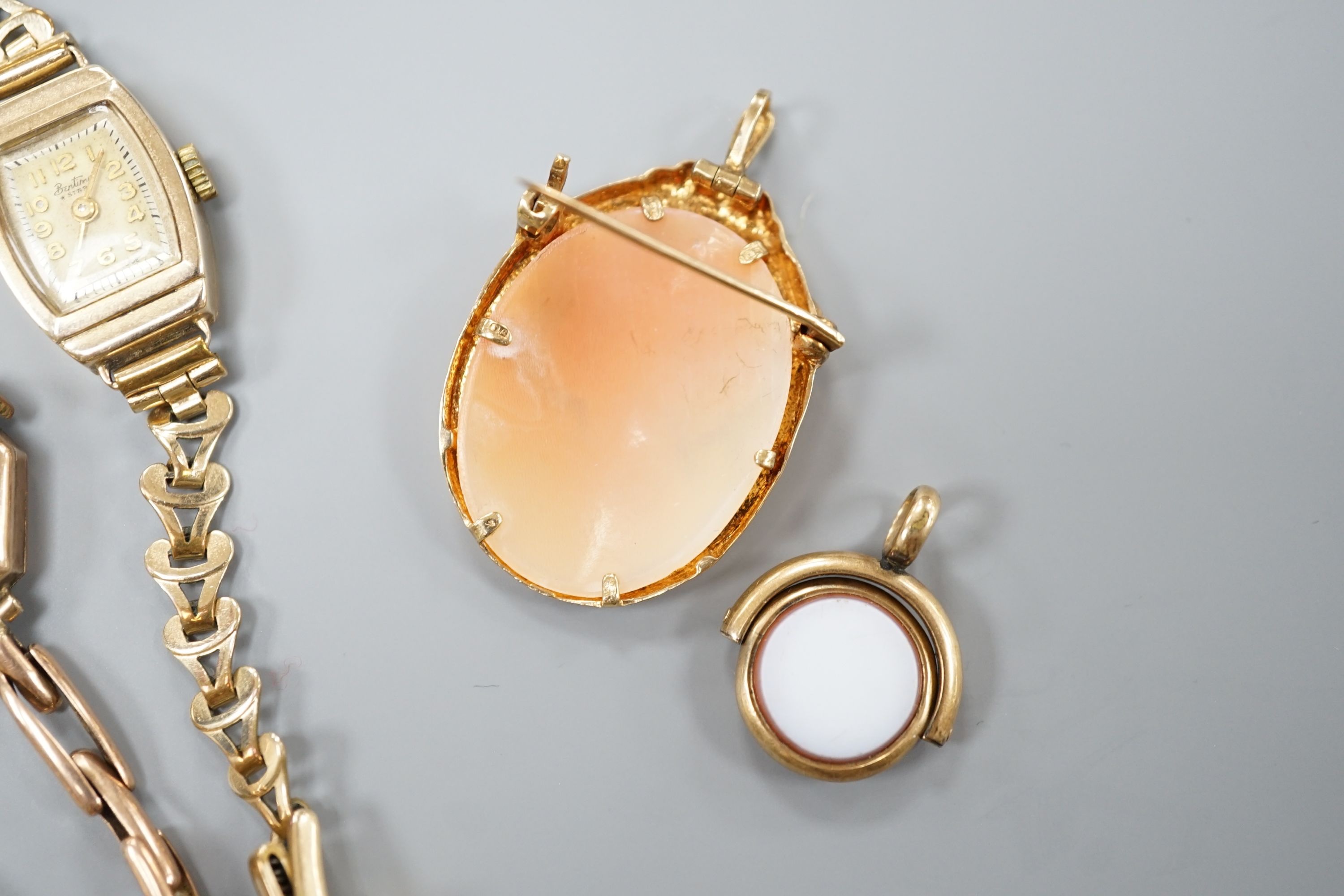 A lady's 9ct gold manual wind wrist watch, on a 9ct expanding bracelet gross 13.6 grams, one other lady's 9ct gold watch on a gold plated bracelet, a modern 9ct gold mounted oval cameo shell brooch and a carnelian and bl